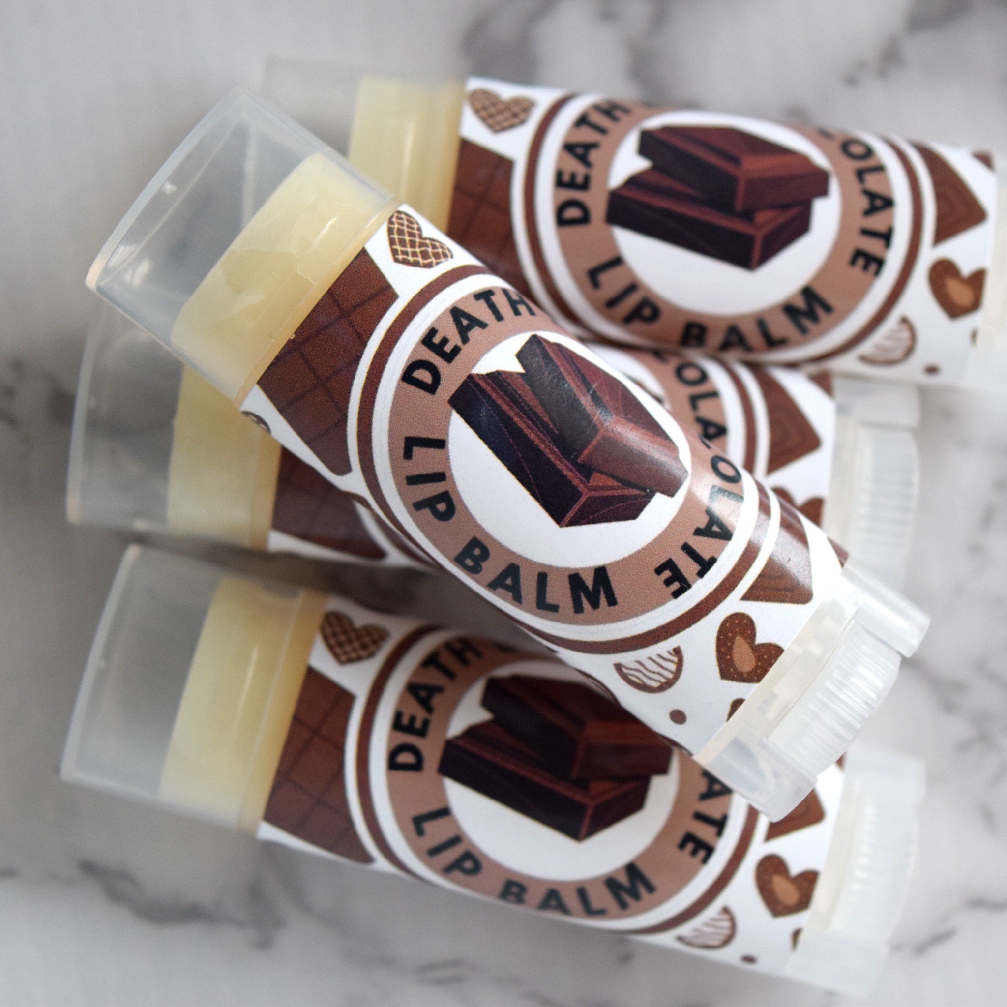 Lip balm tubes with brown and white labels, clear caps, and "Death Lip Balm" text