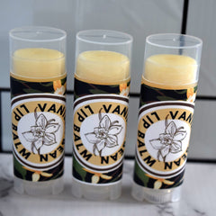 Lip balm tubes with yellow balm, clear cap, and "VANILLA LIP BALM" label on a white background.