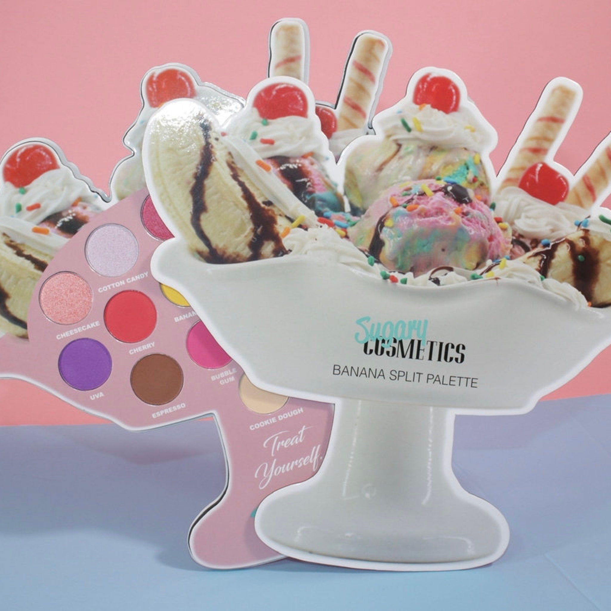 Makeup palette with pink, purple, and brown eyeshadows, and Sugary Cosmetics Banana Split text on white dish.
