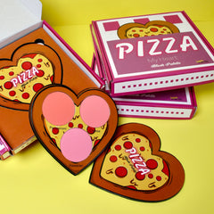 Side view of pizza-shaped blush palette showing six heart-shaped eyeshadows in warm pink and bronze shades.