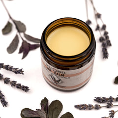 Side view of sleek black balm jar with vegan tattoo aftercare label, showcasing lavender and peppermint ingredients