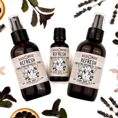 Botanical skincare products with brown glass bottles, white labels, and Wild Rose branding