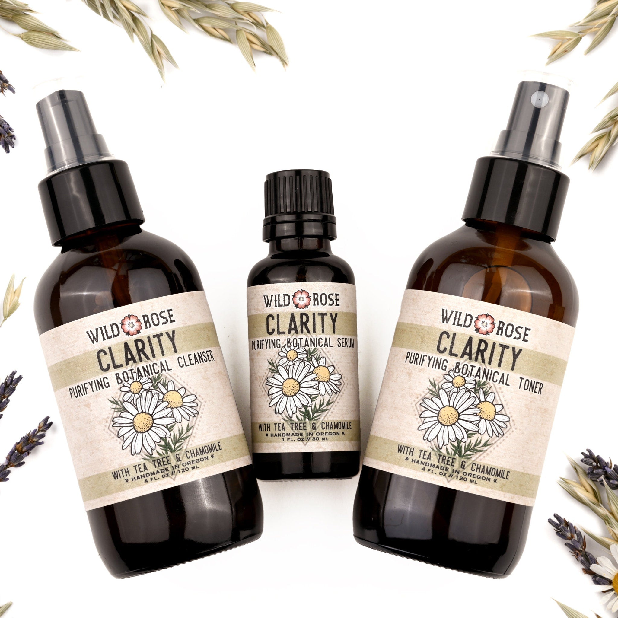 Botanical skincare products in brown glass bottles with floral labels, Wild Rose Clarity brand