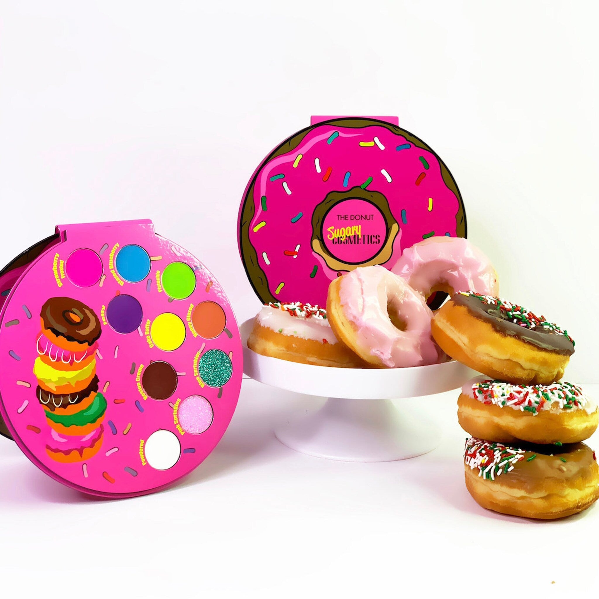 Side view of Donut Palette showing six round pastel eye shadows in pink, purple, and gold hues with embossed designs