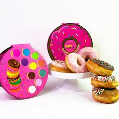 Side view of Donut Palette showing six round pastel eye shadows in pink, purple, and gold hues with embossed designs