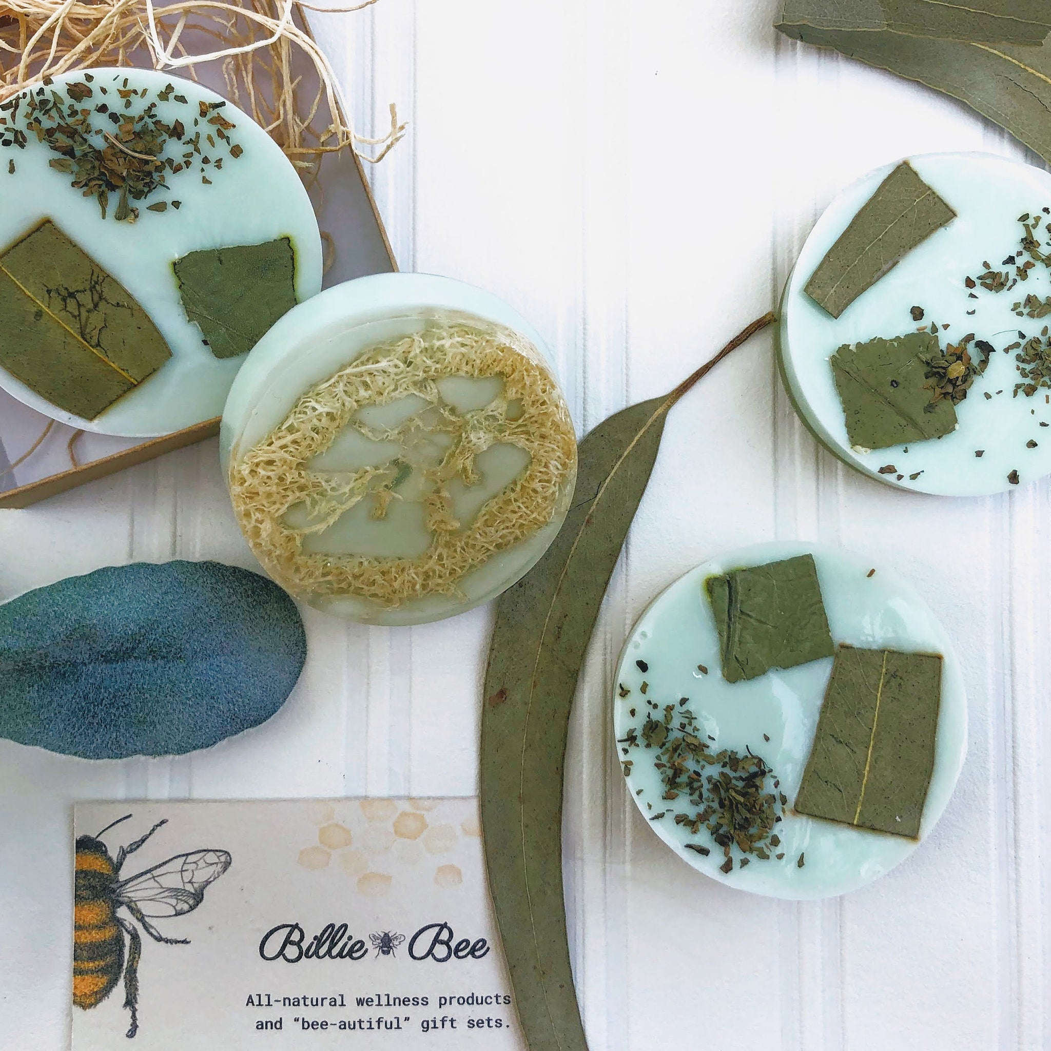 Round soap with light blue color, green leaves, and Billie Bee Products branding