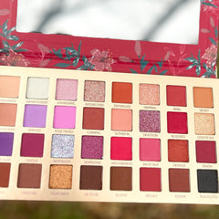 Close-up of Pigmented Bad Blood Eyeshadow in deep crimson with smooth matte finish and compact case