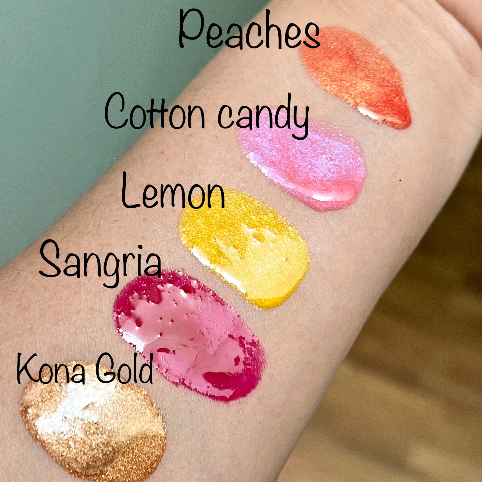Lip gloss swatches, orange shimmer, pink shimmer, yellow, red, and gold glitter on skin