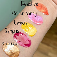 Lip gloss swatches, orange shimmer, pink shimmer, yellow, red, and gold glitter on skin