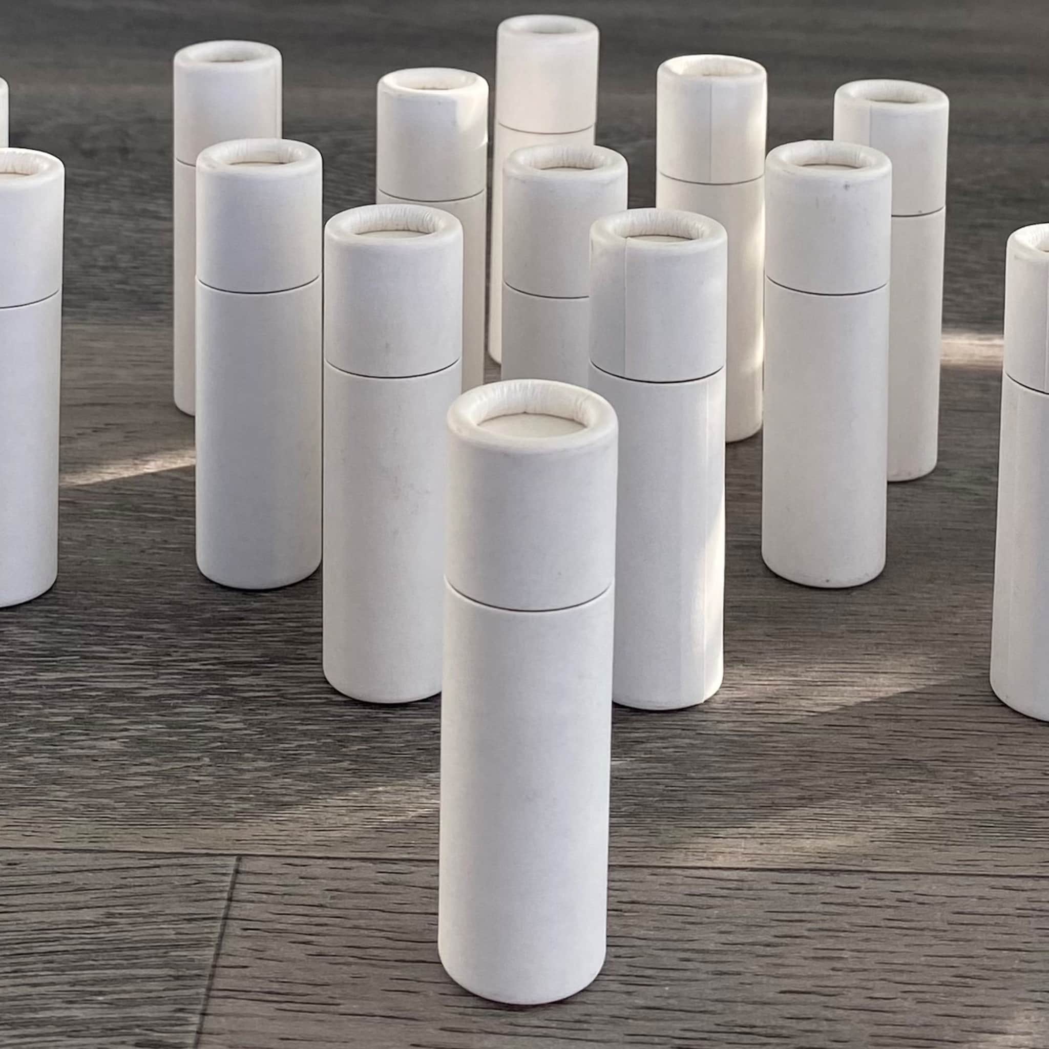 White cardboard tubes with rounded edges arranged on wood grain surface