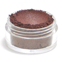 Close-up of burgundy red shimmer eyeshadow being applied to eyelid with brush