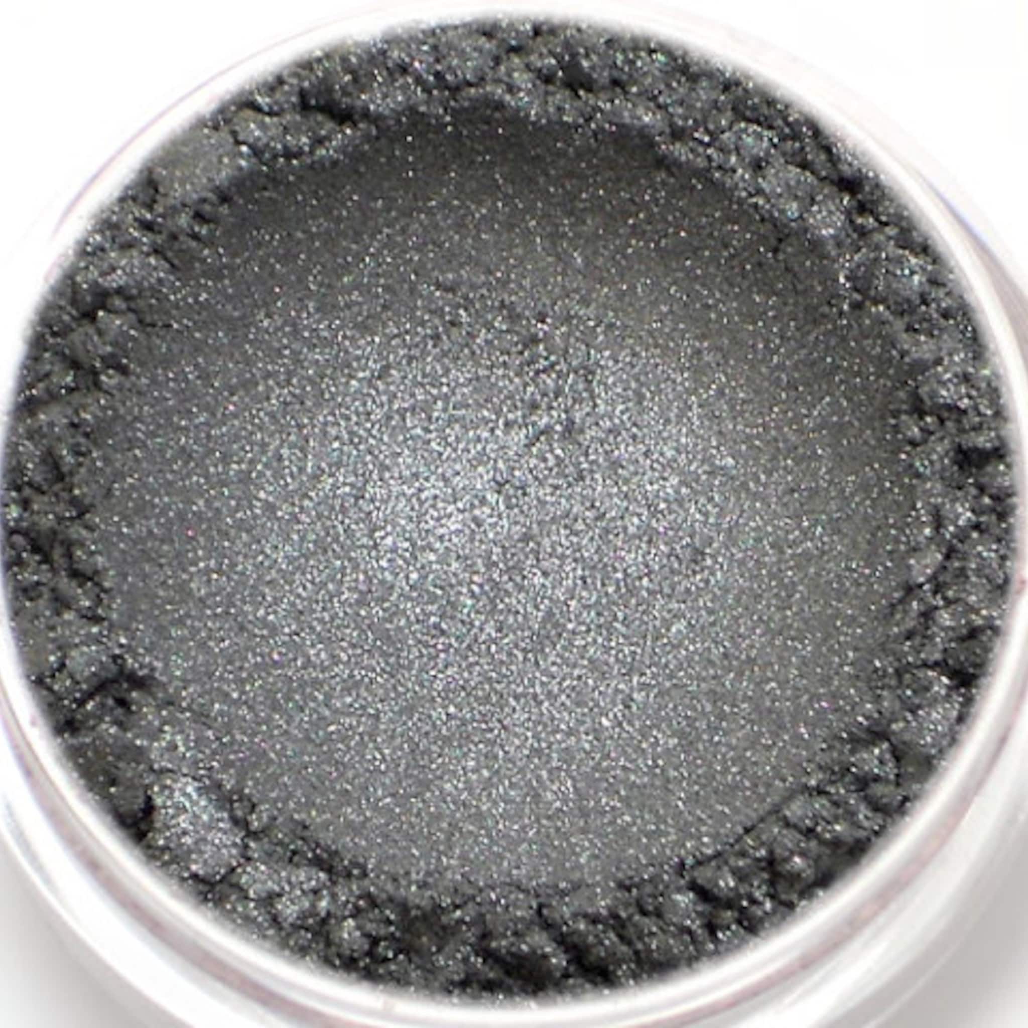 Close-up of dark metallic silver vegan eyeshadow with shimmering mineral pigment in compact case