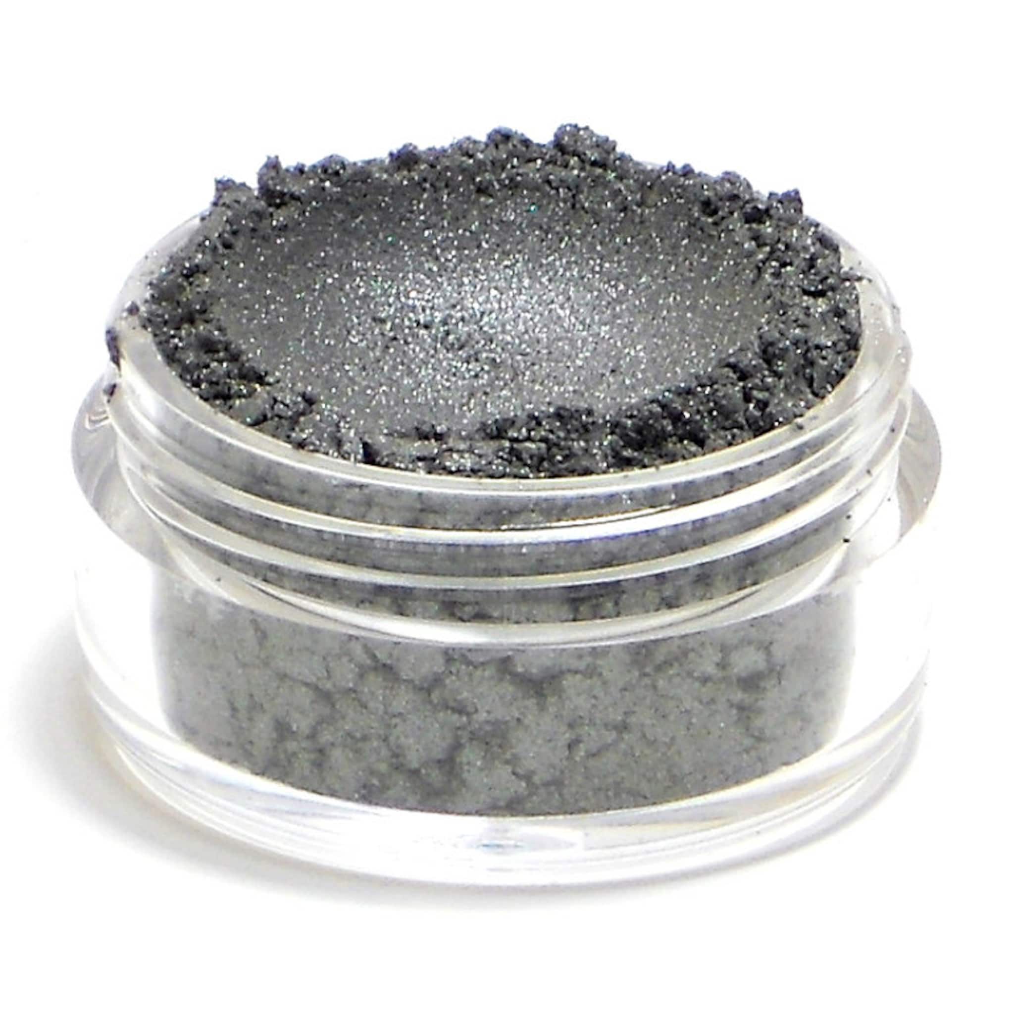 Side view of dark metallic silver vegan eyeshadow pot showing reflective pigment texture