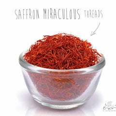 Saffron threads, red-orange strands in a clear glass bowl, Elixir brand visible