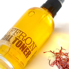 Facial toner bottle with yellow liquid, black cap, and ELIXIRIUM label with saffron near it