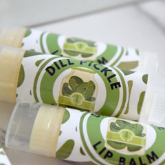 Lip balm tubes with white and green patterned label, clear plastic cap, and visible text "DILL PICKLE