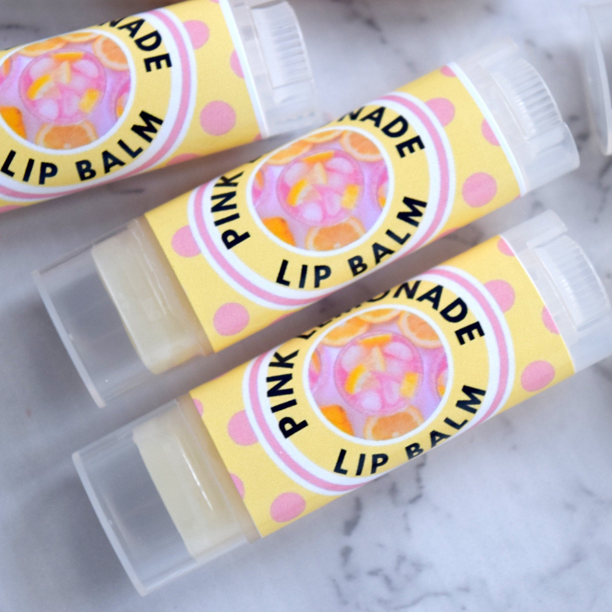 Lip balm tubes with yellow label, pink polka dots, and "Pink Lemonade" text visible