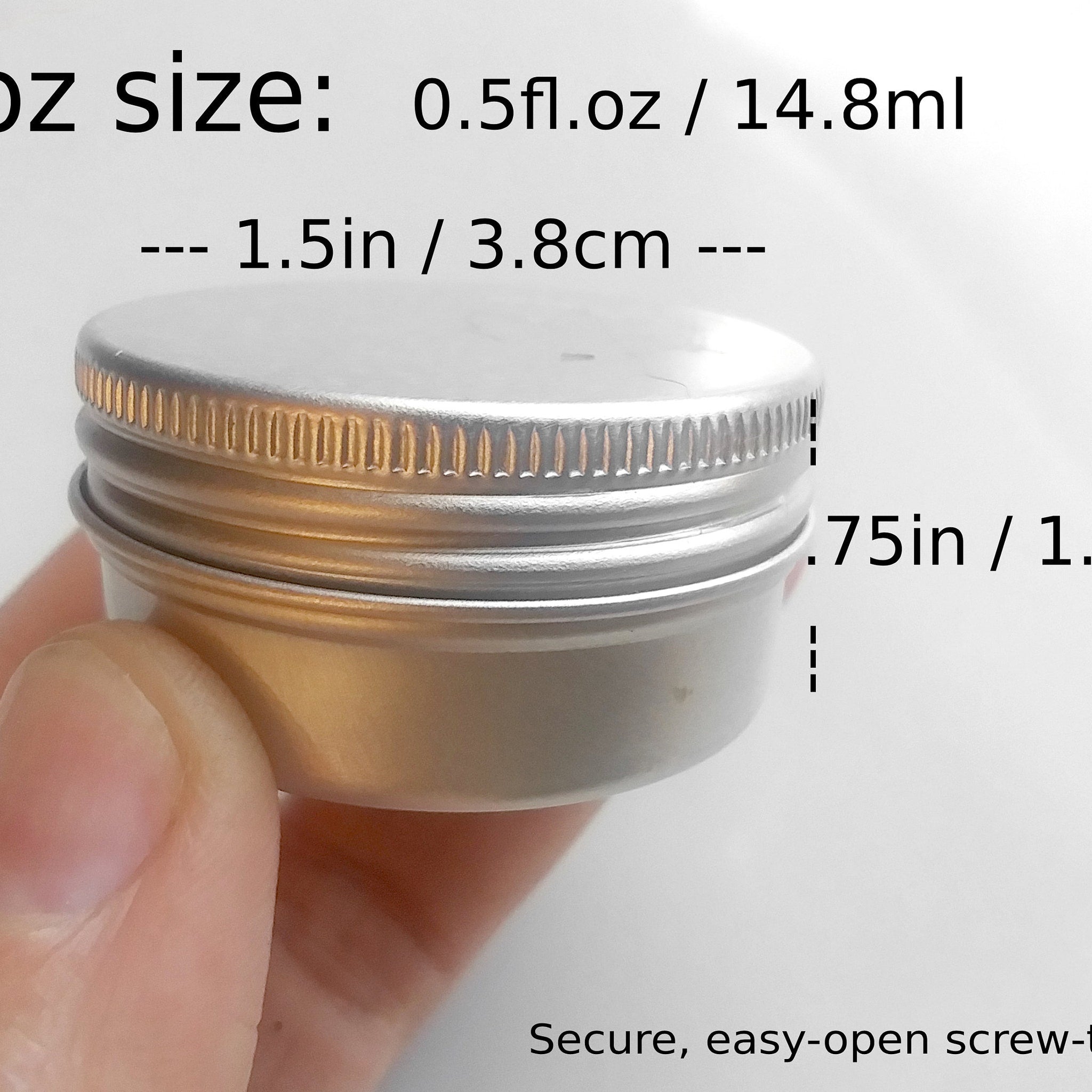 Small metal container with silver lid, screw top, and held by hand