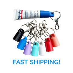 Aquaphor lip repair tube with blue cap, and colorful keychains with silver rings and clasps.