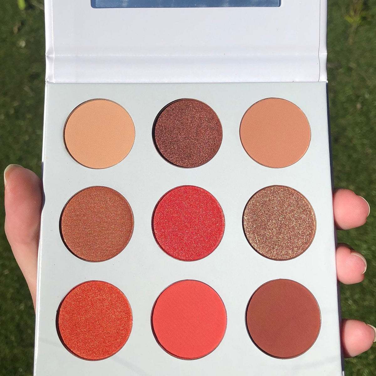 Red Daisies Eye Shadow Palette featuring six vibrant matte and shimmer shades in warm red and pink tones with floral design.
