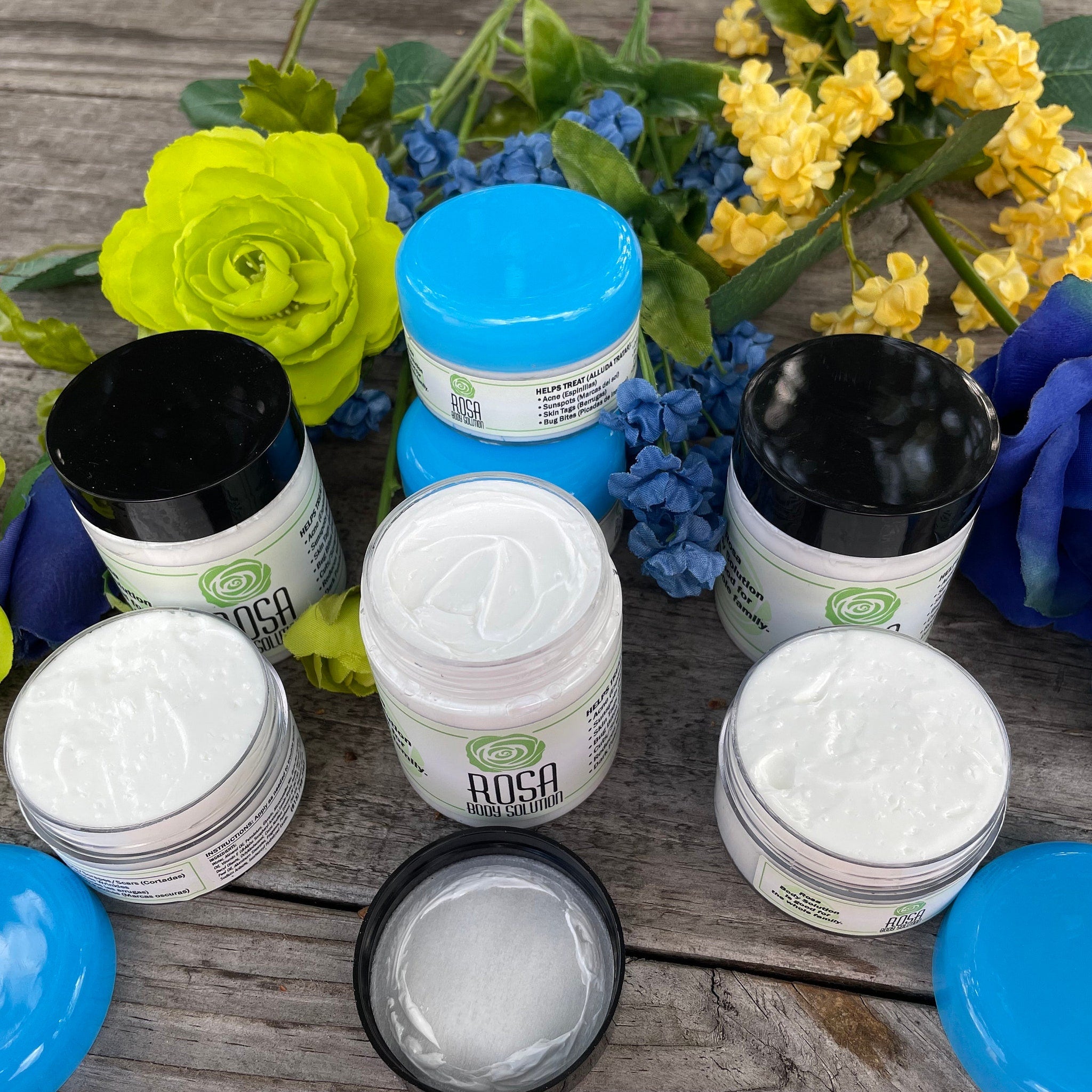 Acne treatment cream in white jars with black and blue lids, Rosa Body Solution brand