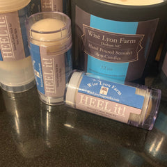 Lotion stick with clear plastic, blue and purple label, and Wise Lyon Farm branding visible