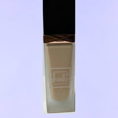 Side view of Shade-Perfect Foundation compact showing matte black case with gold trim and circular pan design