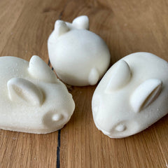Rabbit shaped soaps, white, textured surface, on a wooden surface