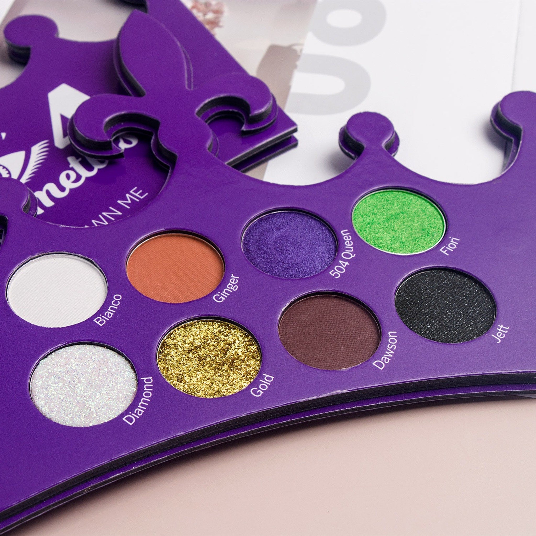 Top-down view of Crown Me Eyeshadow Palette showcasing sleek black compact with gold trim and open layout