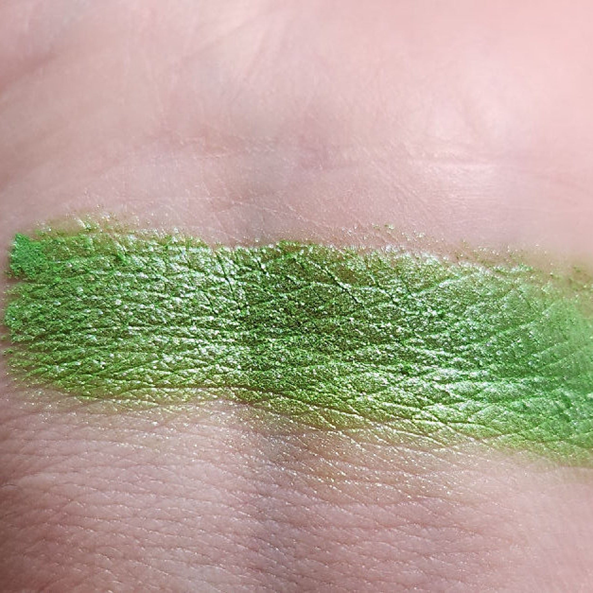 Close-up of vibrant green shimmer eyeshadow palette with smooth, blendable powder texture