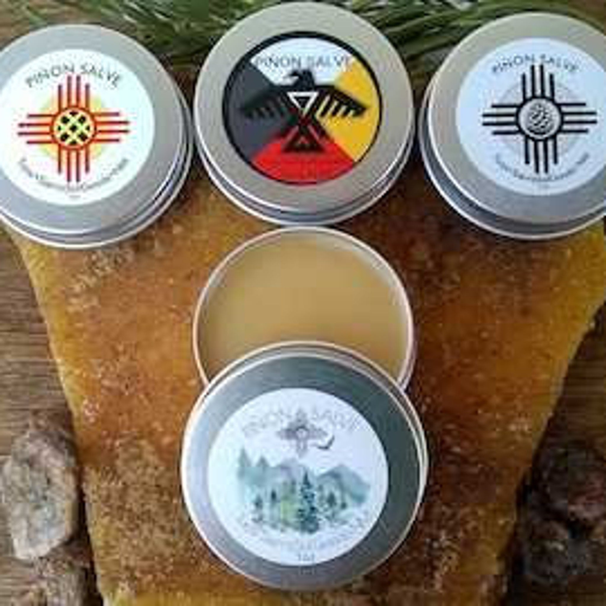 Pion Salve tins, silver metal containers with colorful labels, displayed on a textured surface