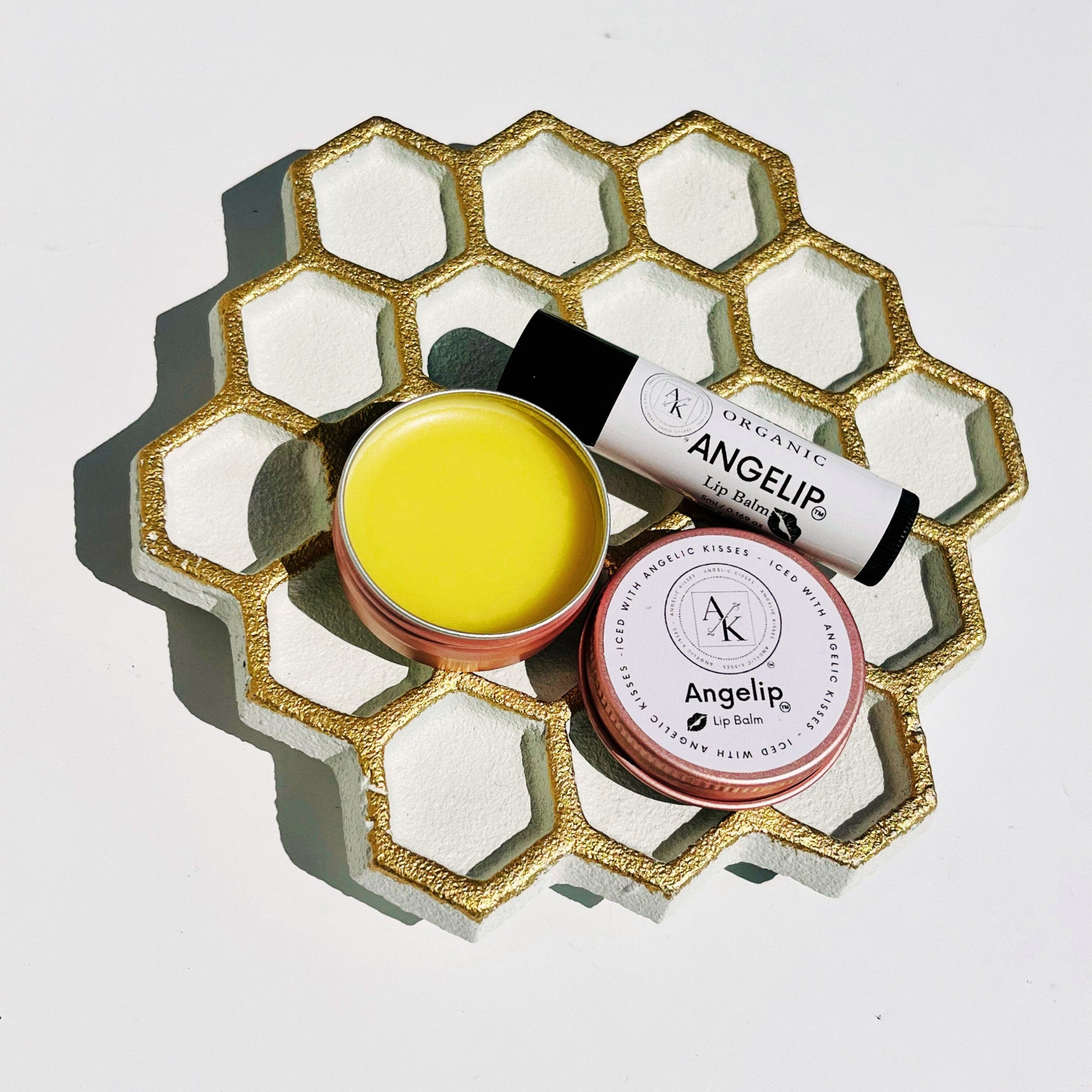 Lip balm with yellow, white, and gold honeycomb tray, Angelip brand visible