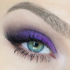 Close-up of vegan mineral eyeshadow in rich purple bishop shade with smokey grey-blue undertones, finely milled texture