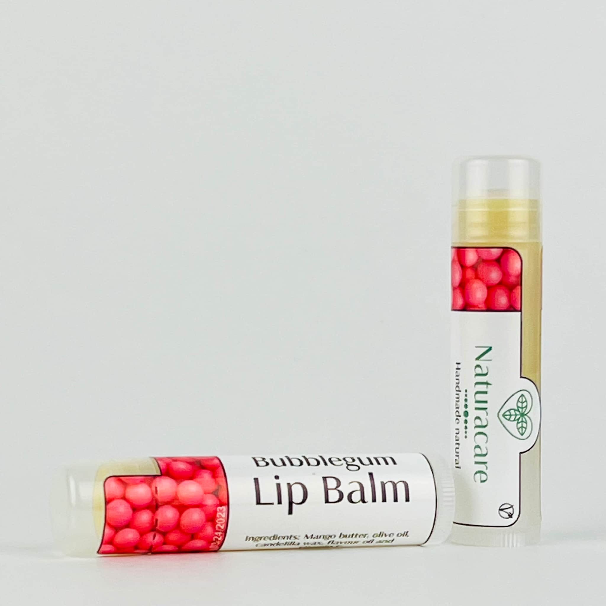 Lip balm tubes with pink spheres, white label, and Naturacare branding, on white background