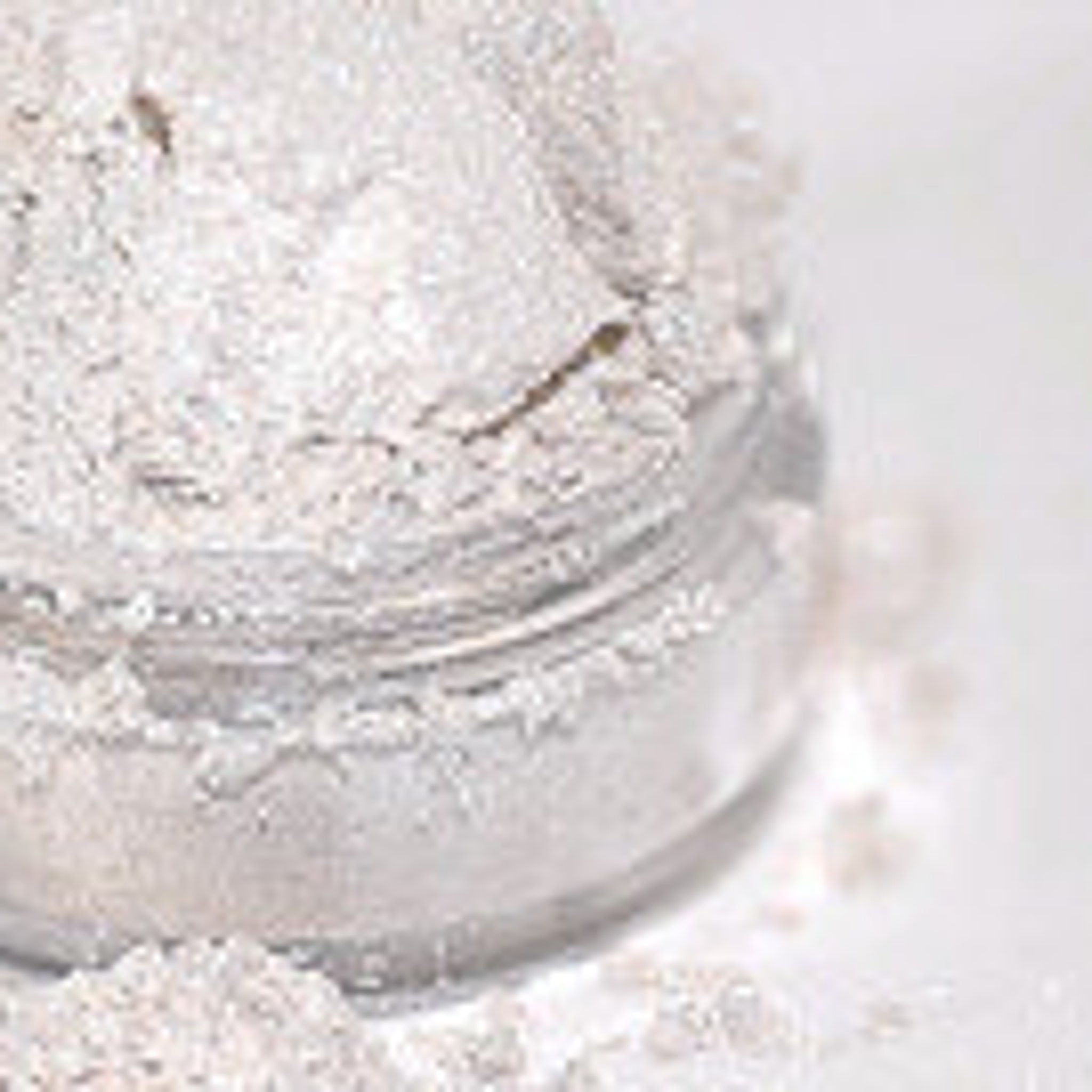 Close-up of shimmering white and pale pink mineral eyeshadow with sparkling fairy glow finish