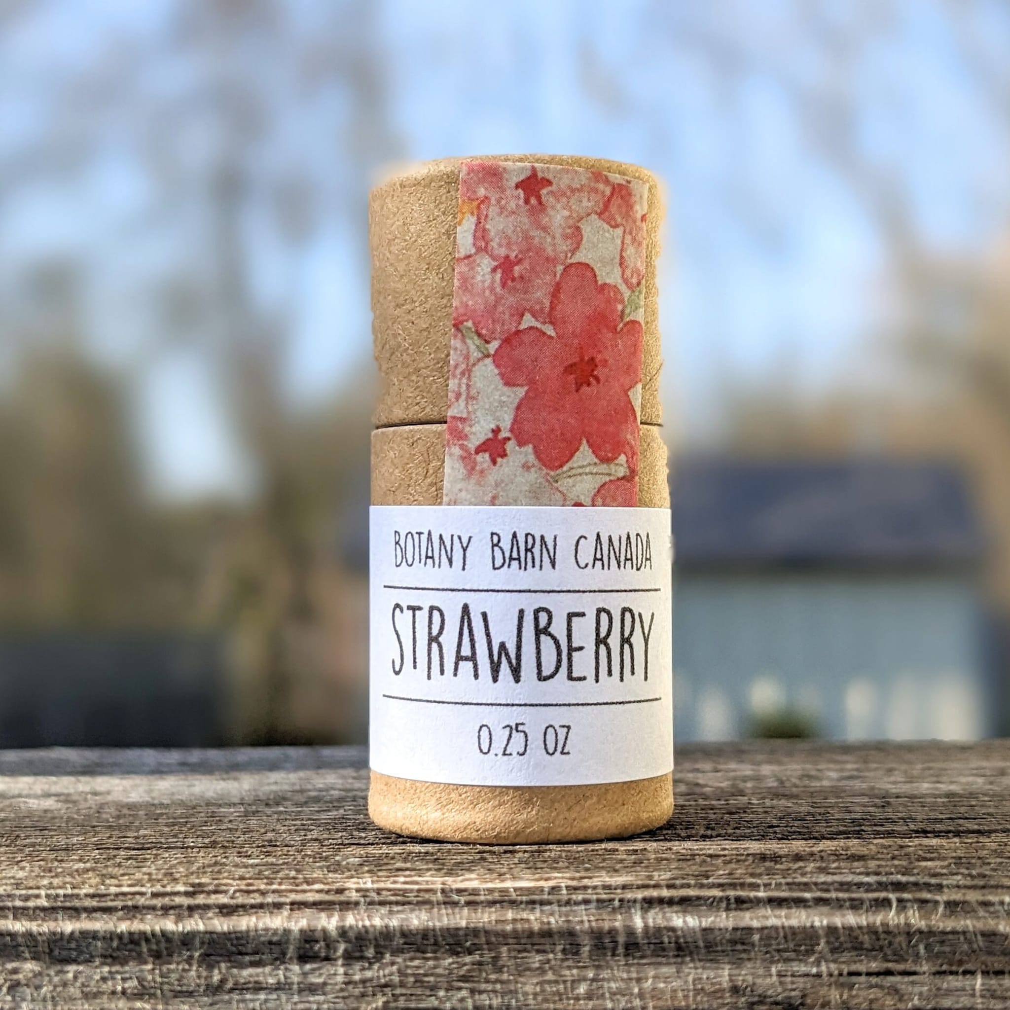 Botany Barn Strawberry product, cylindrical cardboard container with floral pattern and white label on wood surface