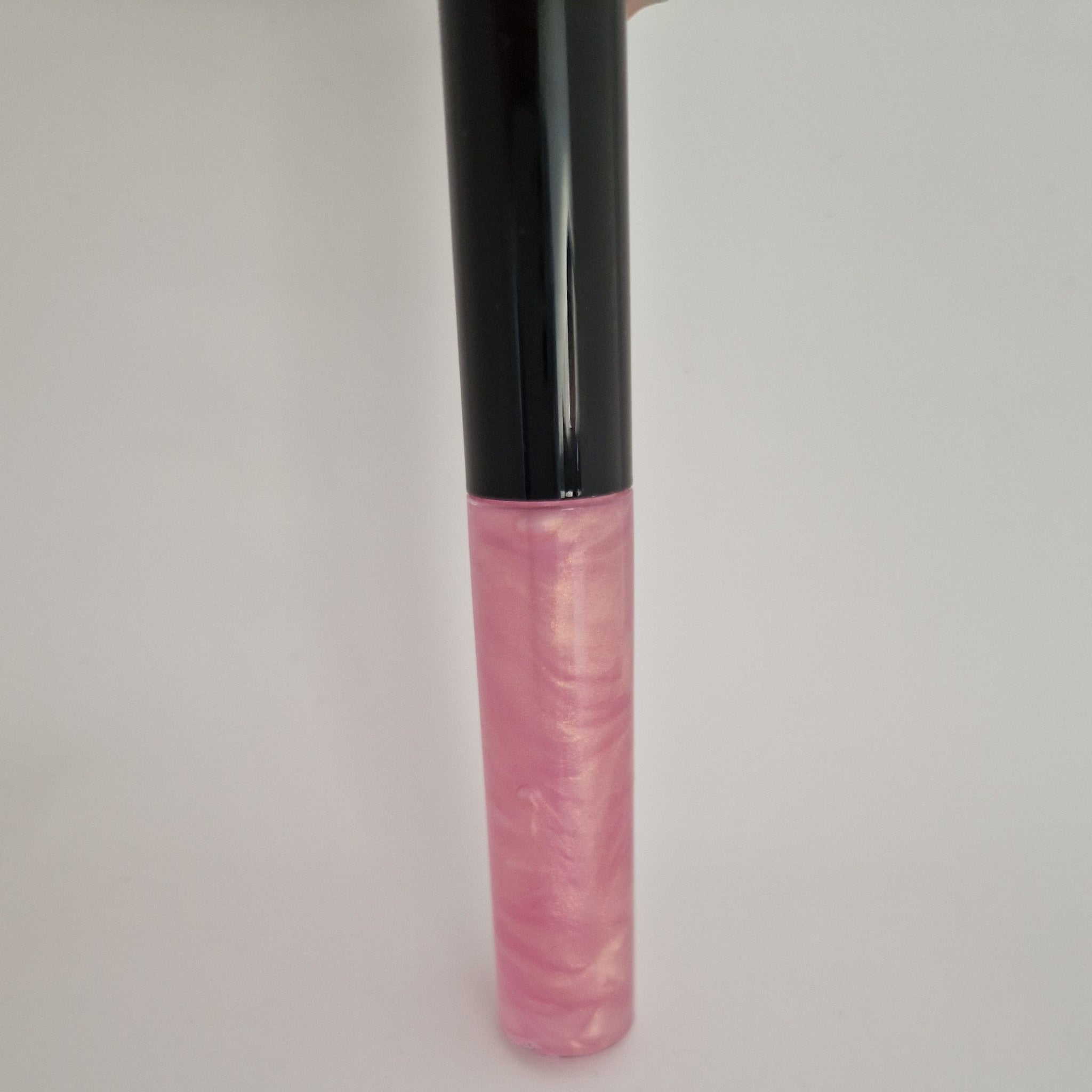 Lip gloss tube with black cap, pink and gold shimmer, for lip application