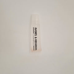 Lip gloss tube, clear plastic with Ivory & Obsidian Cosmetics text, light pink tint
