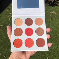 Close-up of the Red Daisies Eye Shadow Palette showing vibrant matte red and shimmer pink shades with floral imprint.