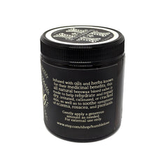 Side view of amber glass jar with all-natural herbal salve, showcasing creamy texture and minimalist label design