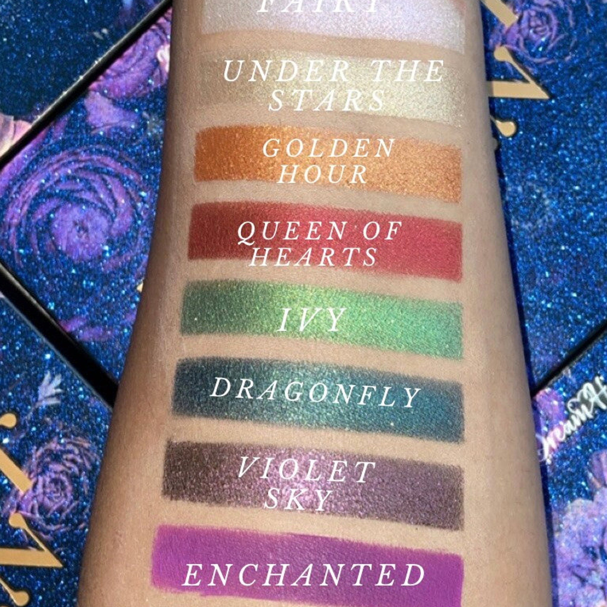 Midnight Garden palette open with bonus dual-ended eyeshadow brush nestled beside vibrant pans