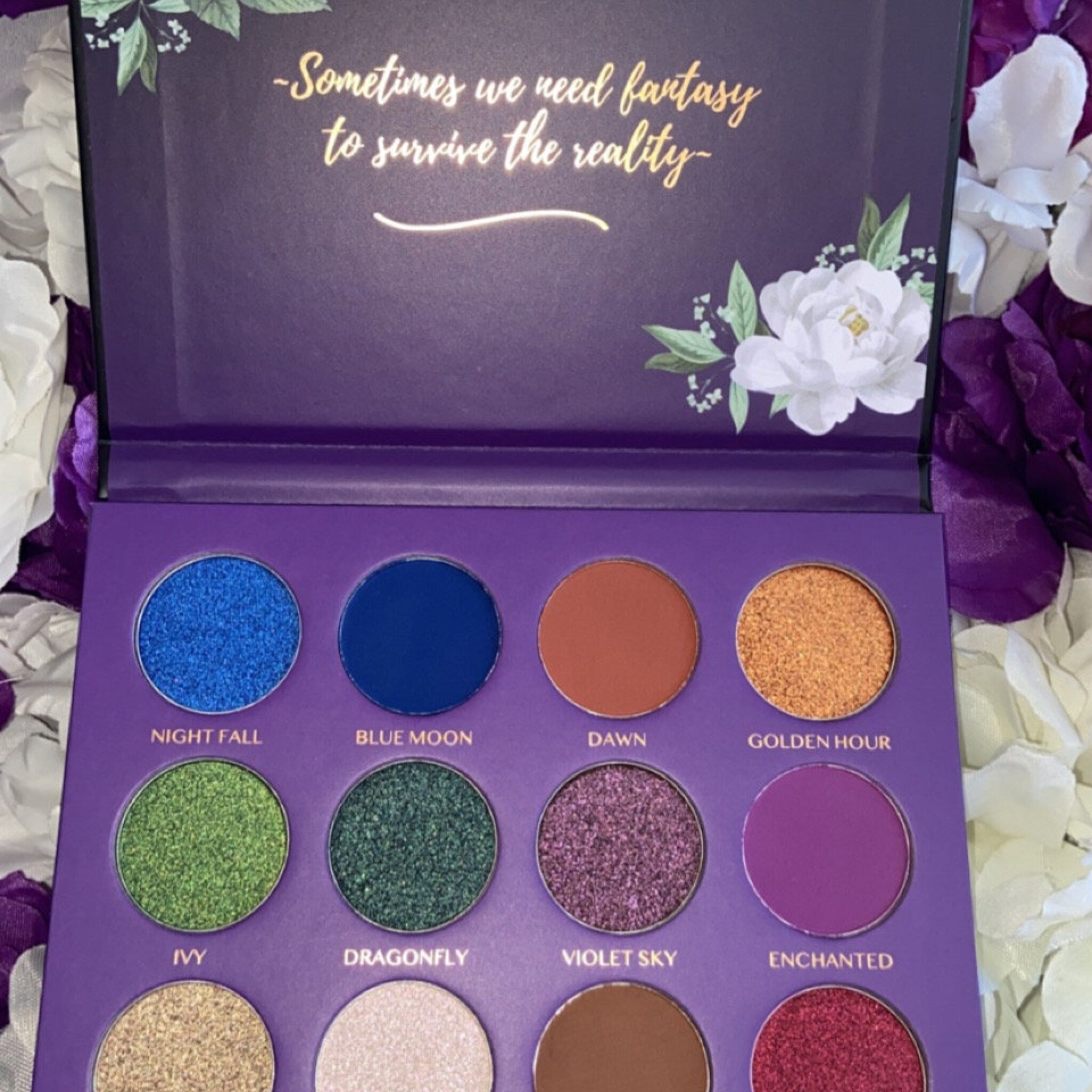 Side view of Midnight Garden Eyeshadow Palette showing sleek black case with floral design and open pans of shimmering shades