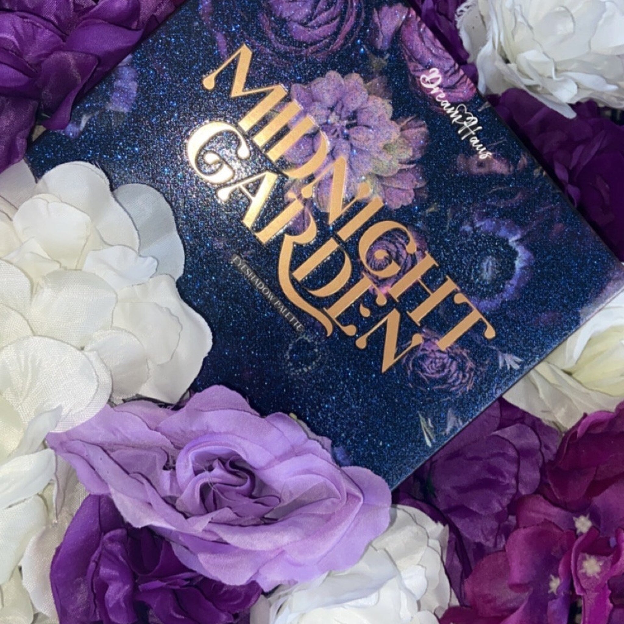 Side view of Midnight Garden Eyeshadow Palette showing sleek black compact with floral embossing and open layout