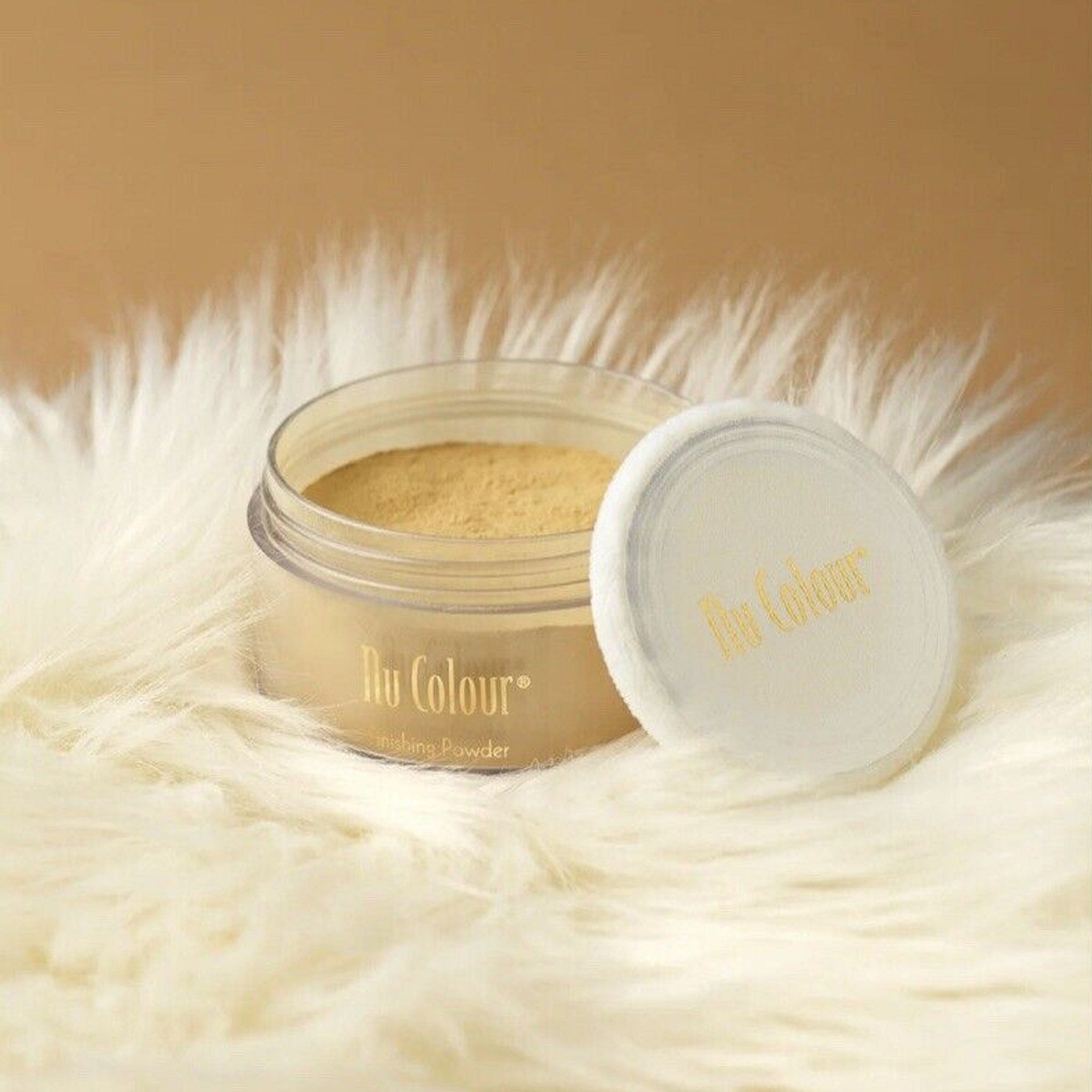 Face powder in clear jar with yellow powder, white puff, and Nu Colour text
