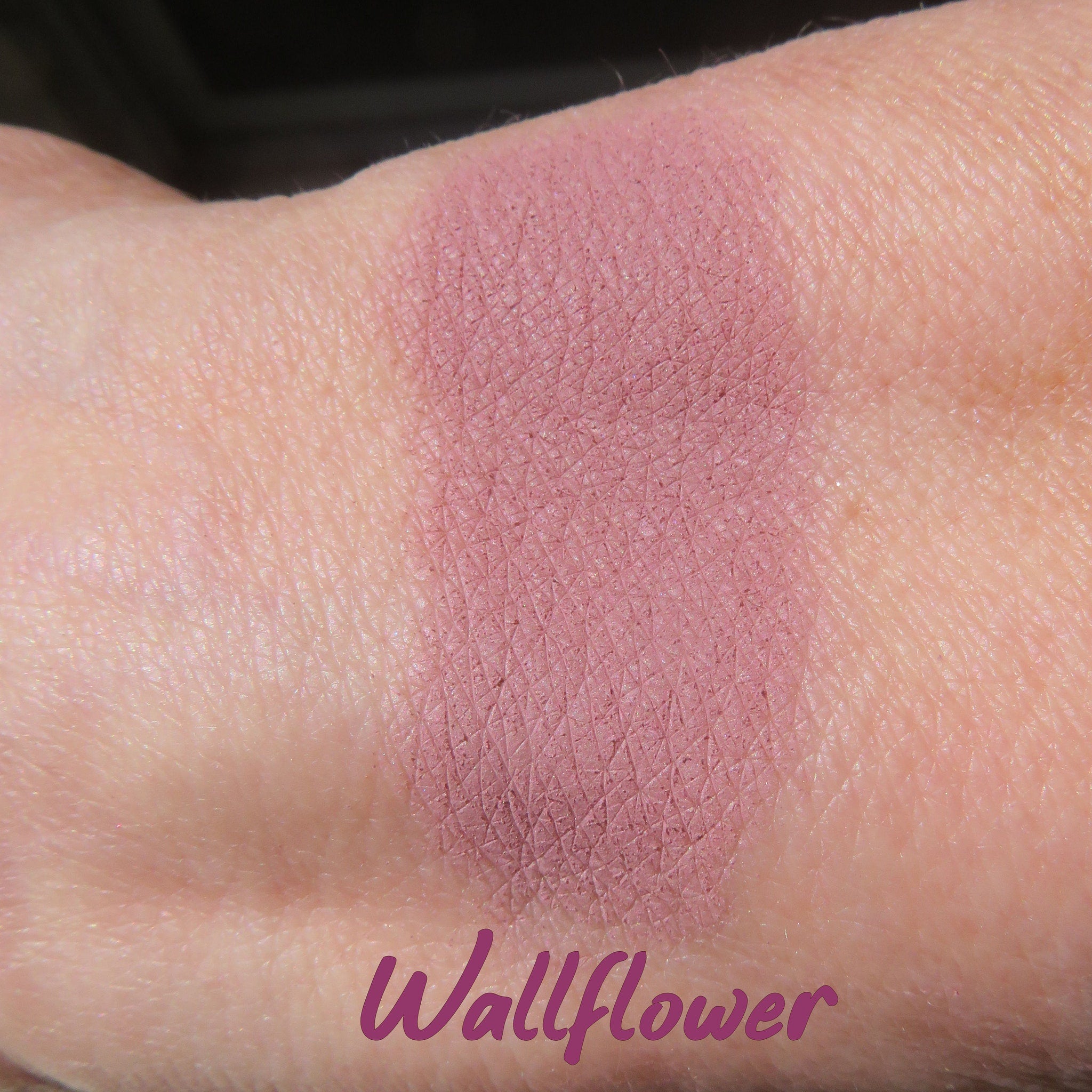 Side view of matte purple mineral eyeshadow in loose powder form with vegan and cruelty-free label visible