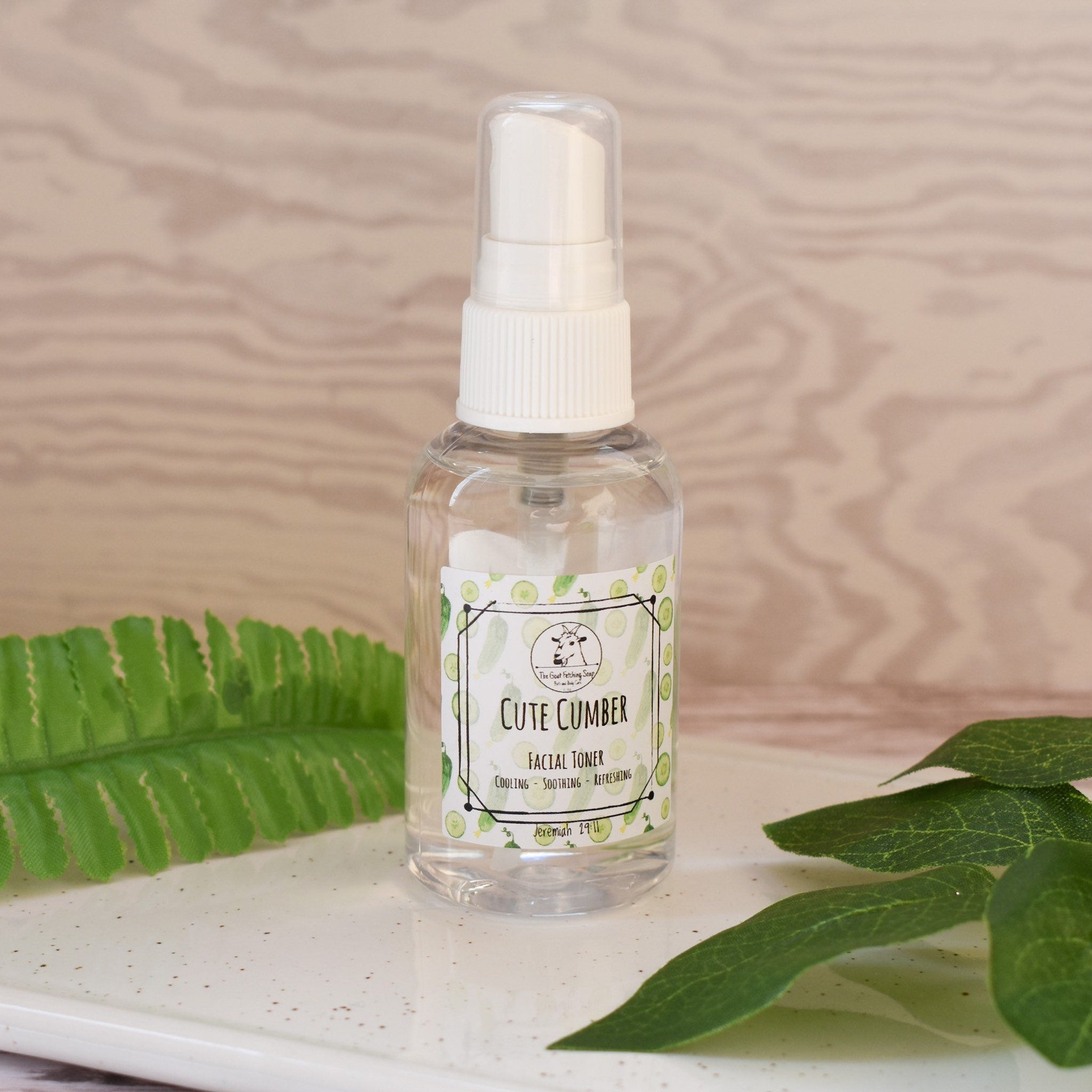 Facial toner bottle, clear plastic, white cap, "Cute Cumber" label, on a tray