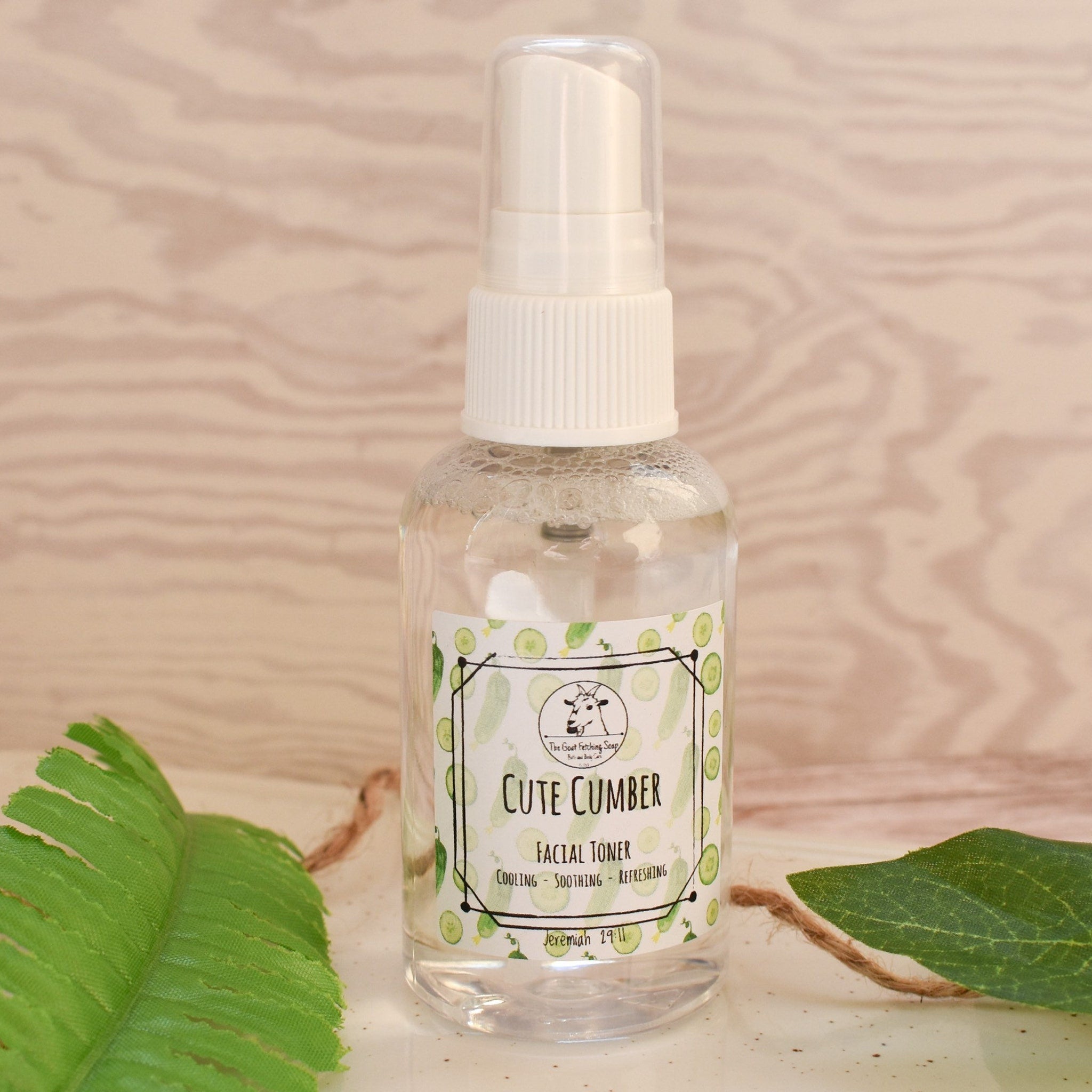 Facial toner bottle with white pump, clear liquid, and Cute Cumber label on wood background