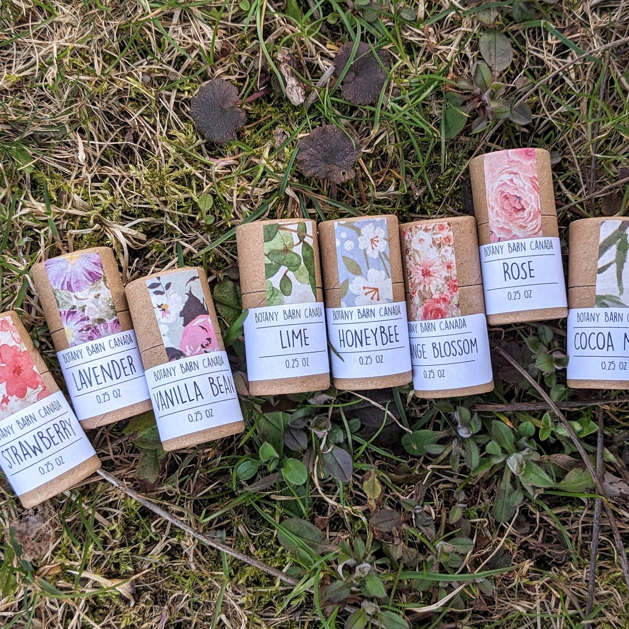 Botanical tubes with floral patterns, Botany Barn Canada branding, on grass