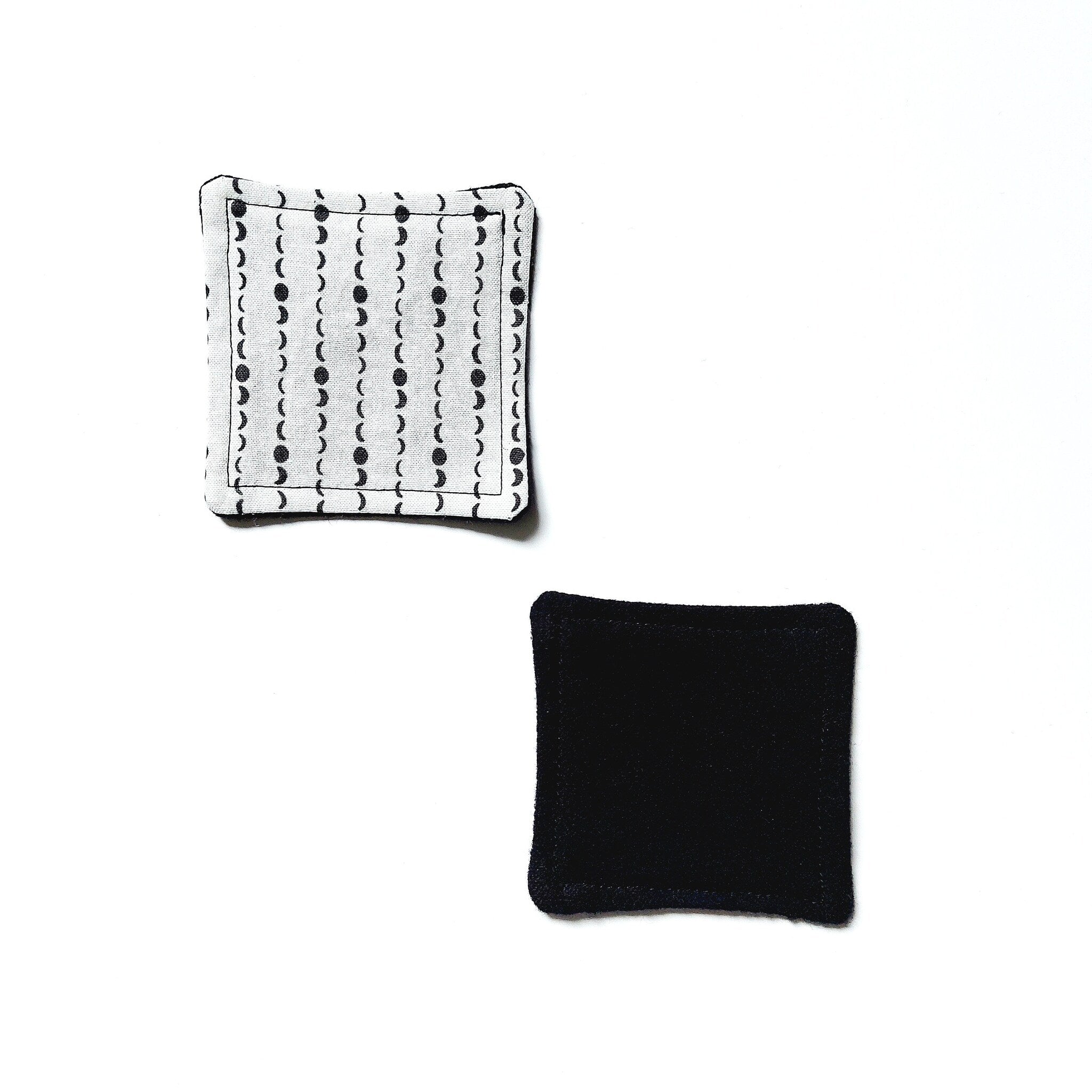 Coaster set with black and white patterned fabric and solid black fabric square shapes