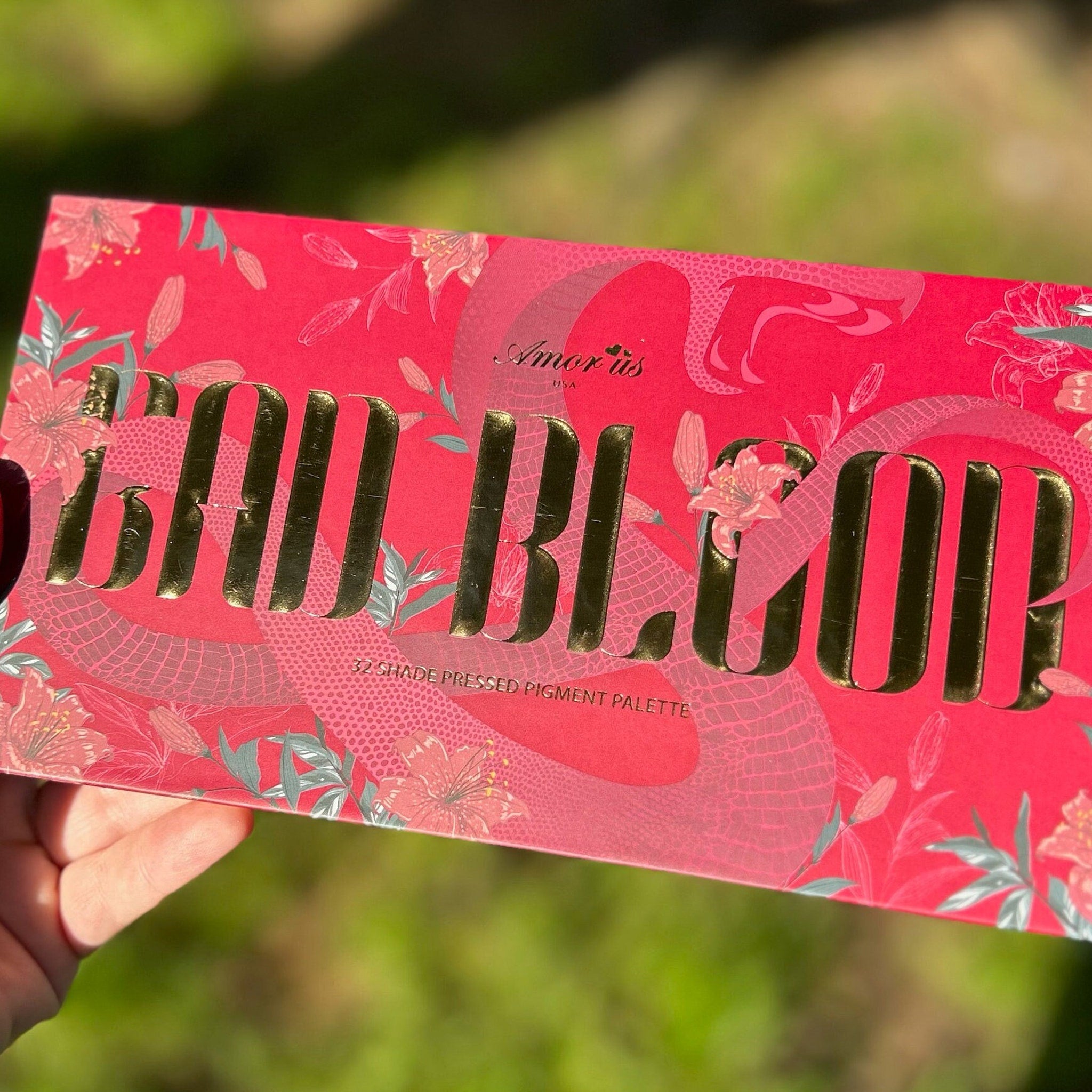 Open compact showing deep red pigmented eyeshadow with smooth matte finish and black case